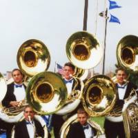 Alumni march band members pose for a group photo with their tubas